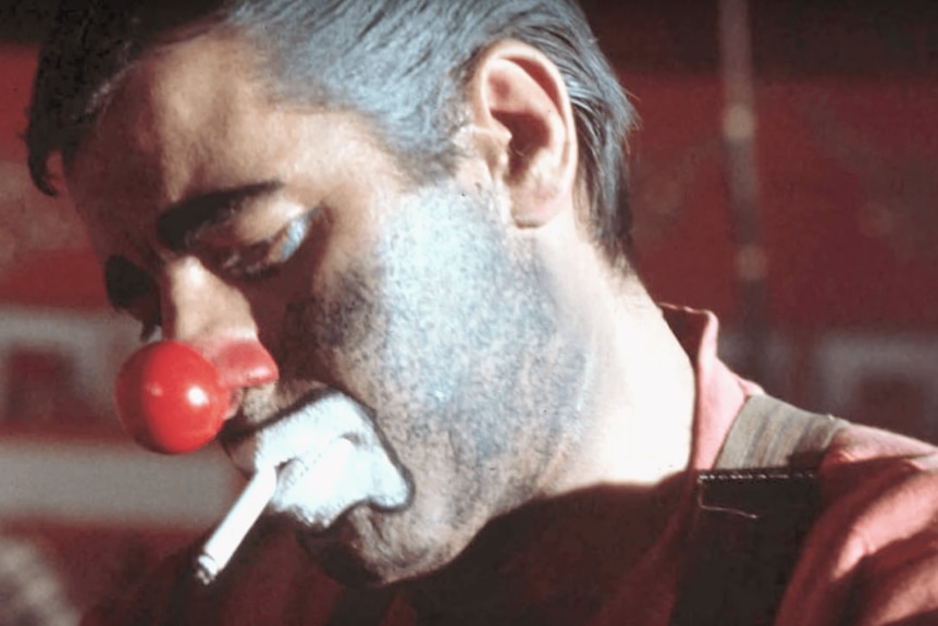 Une scène du film montrant un homme en maquillage de clown fumant une cigarette.