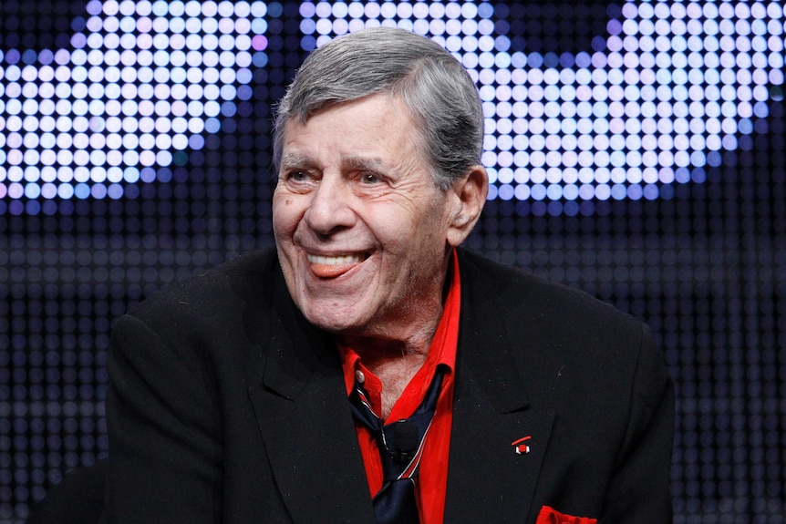 L'acteur et comédien Jerry Lewis sourit avec sa langue sortie.