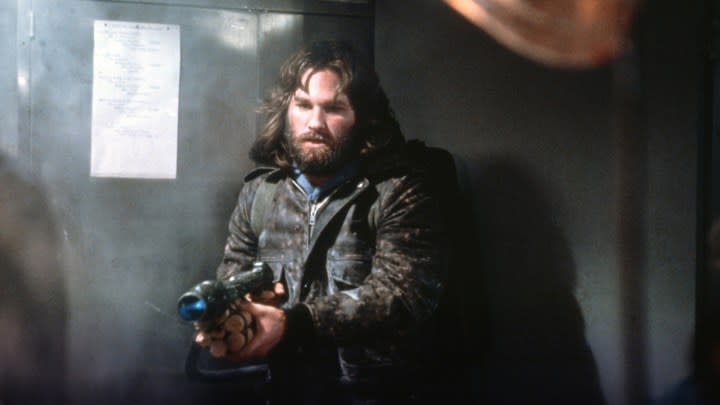 Un jeune Kurt Russell tenant une arme dans le film The Thing.