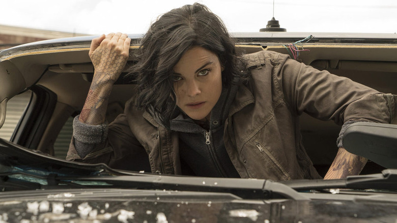 Jane regardant par la fenêtre cassée d'une voiture dans Blindspot