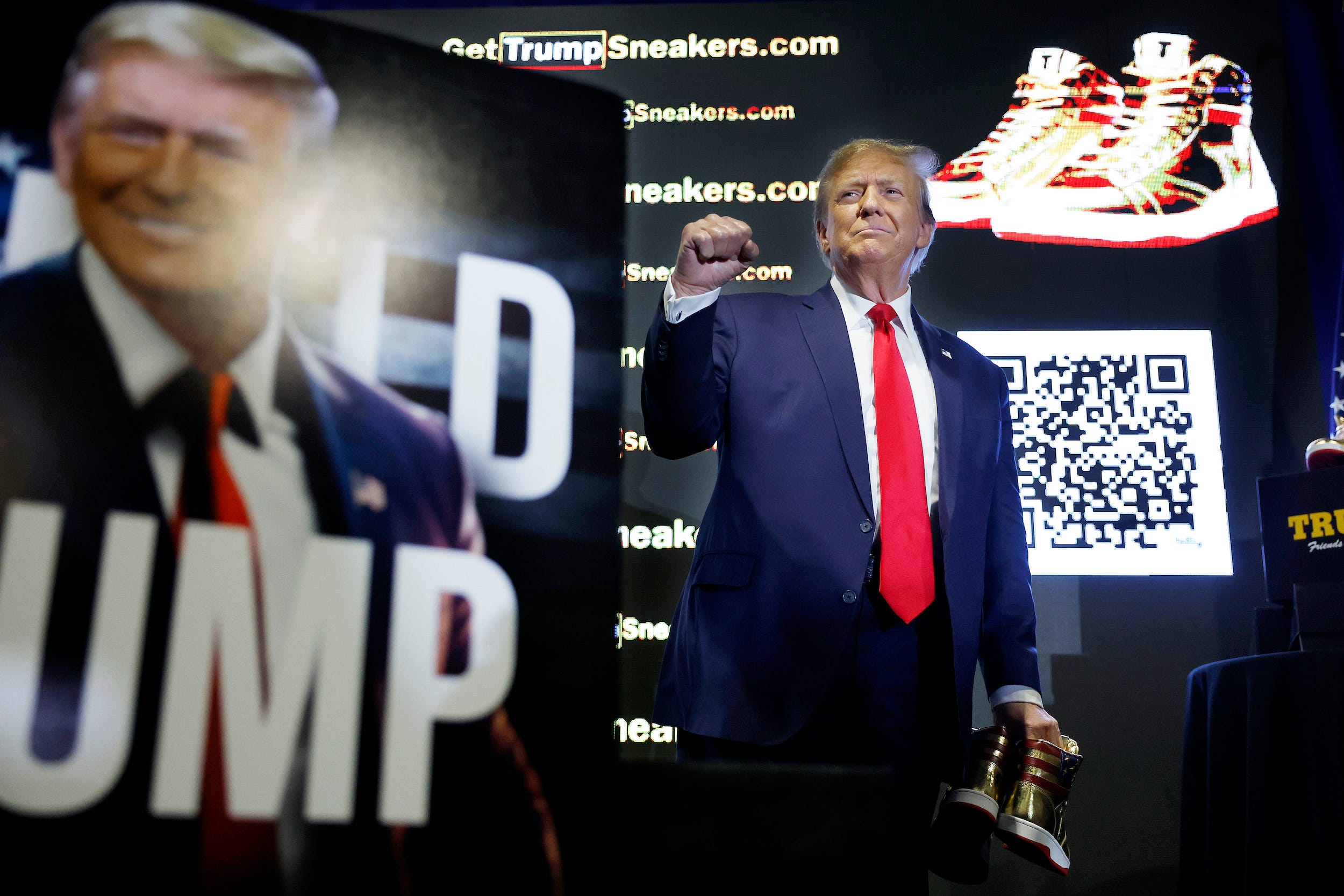Donald Trump tenant une paire de ses chaussures brandées Trump