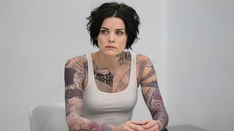 Jane Doe assise à une table dans Blindspot