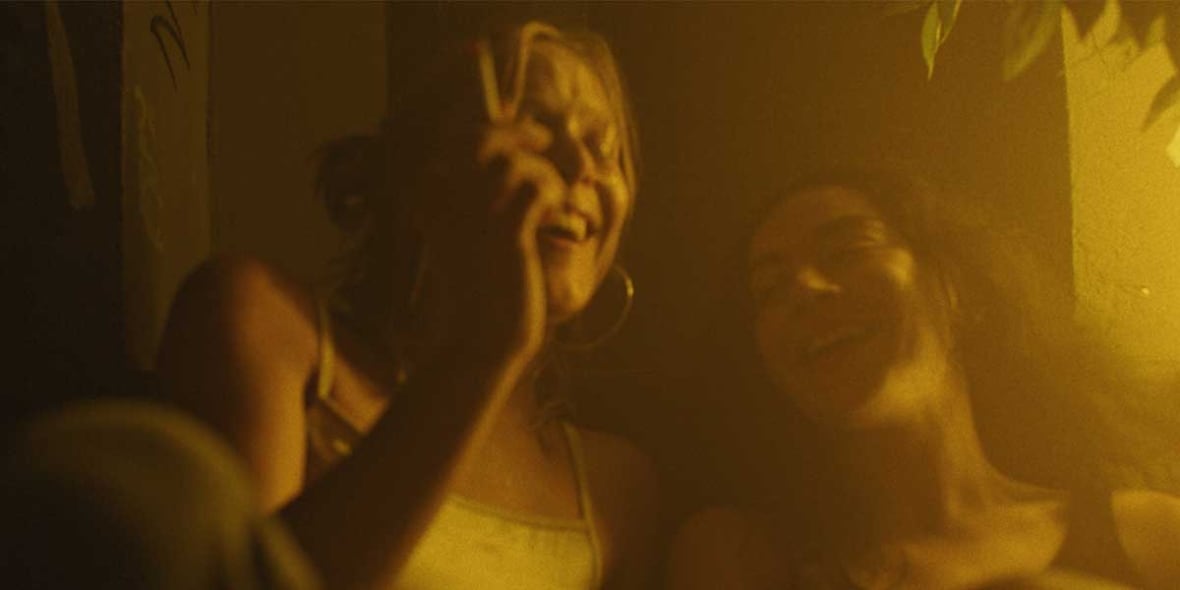 Une image du film Erupcja. Deux femmes sont vues ensemble en riant. Elles sont photographiées dans des tons dorés.