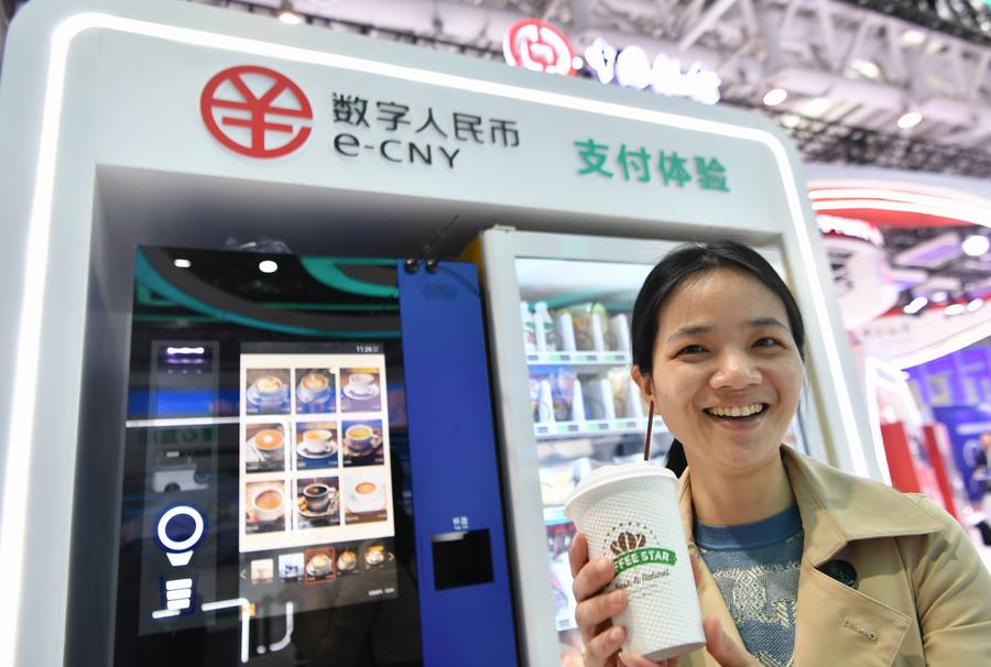 Une visiteuse tenant une tasse de café achetée avec le yuan numérique chinois, e-CNY, le 26 avril 2023.