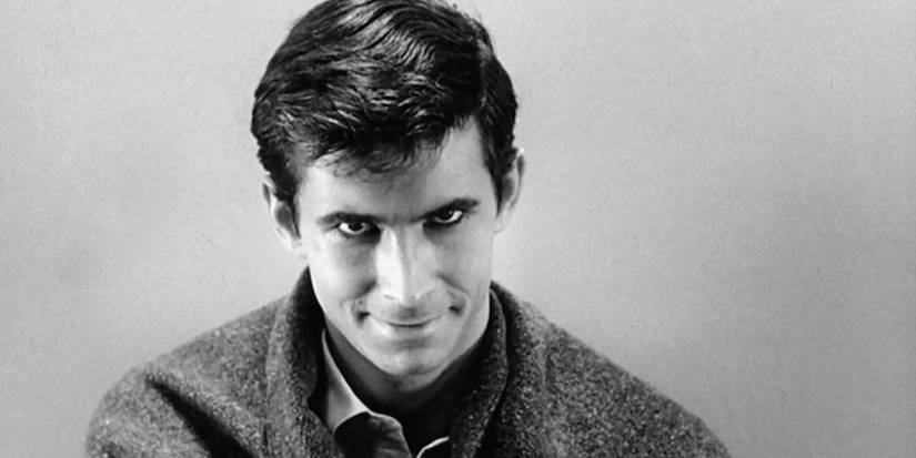 Norman Bates regardant l'objectif et souriant dans Psychose.