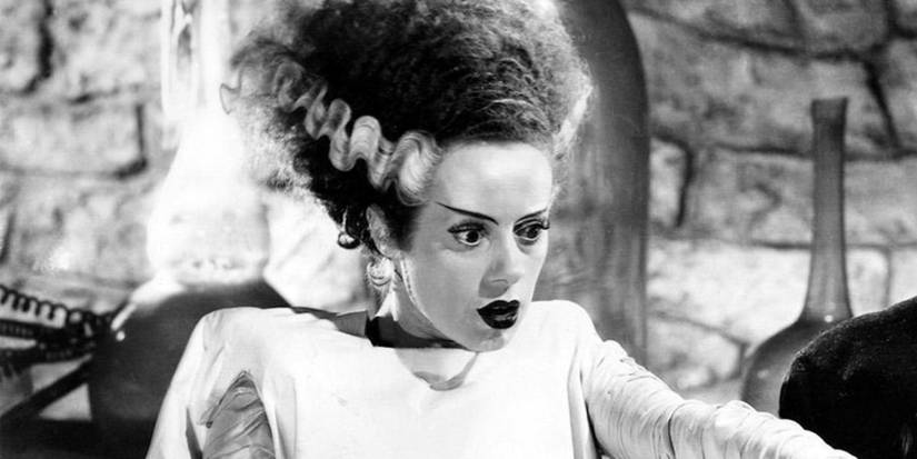 La Fiancée pointant du doigt quelque chose hors champ dans La Fiancée de Frankenstein.