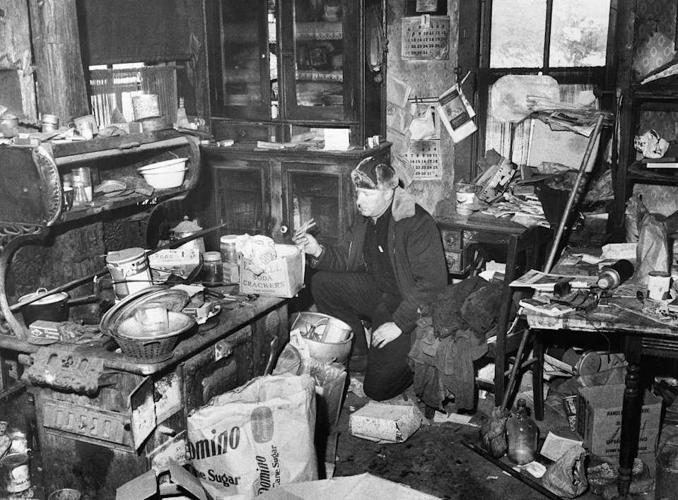 Un policier examine la cuisine encombrée de la ferme d'Edward Gein, où les autorités ont trouvé des crânes humains et d'autres parties de corps humains.