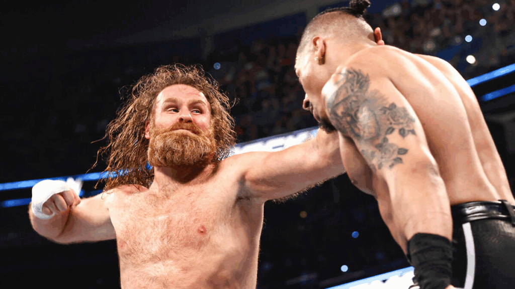 Sami Zayn portant un coup de poing à Carmelo durant leur match