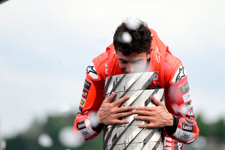 Marc Márquez après sa victoire au GP du Japon, tenant la plaque symbolisant son neuvième titre mondial, le septième en MotoGP