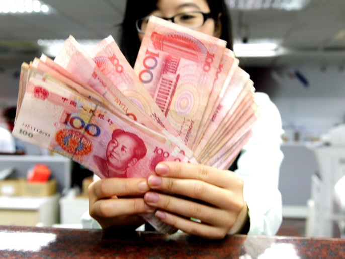 Un employé compte des billets de Yuan à un bureau de poste à Taipei