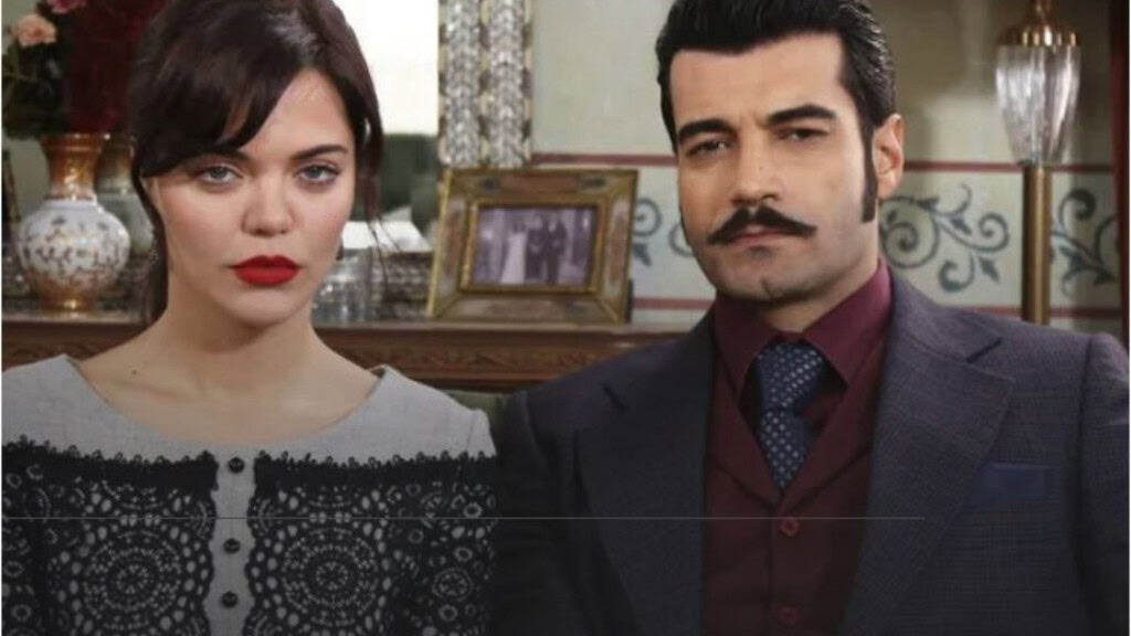 Deux personnages assis dans un intérieur classique, une femme au rouge à lèvres et un homme en costume sombre.
