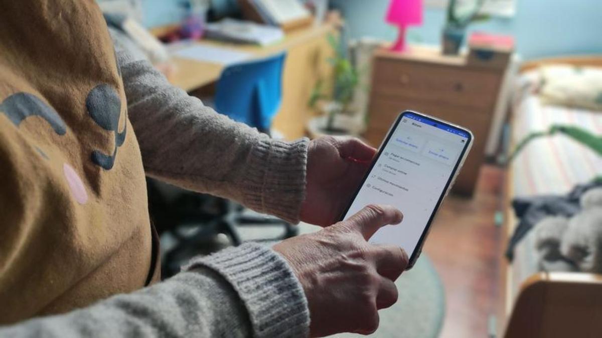 Une femme effectue un Bizum depuis son téléphone mobile.