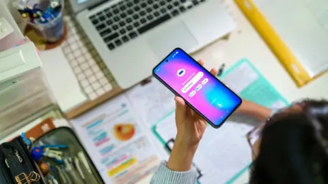 Une étudiante interagissant avec un chatbot IA sur son smartphone