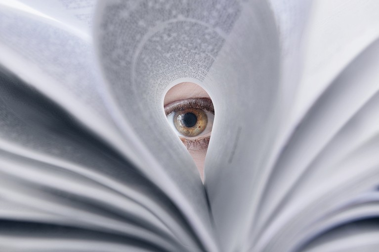 Eye looking through printed journal pages.