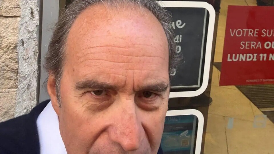 Xavier Niel devant un supermarché.