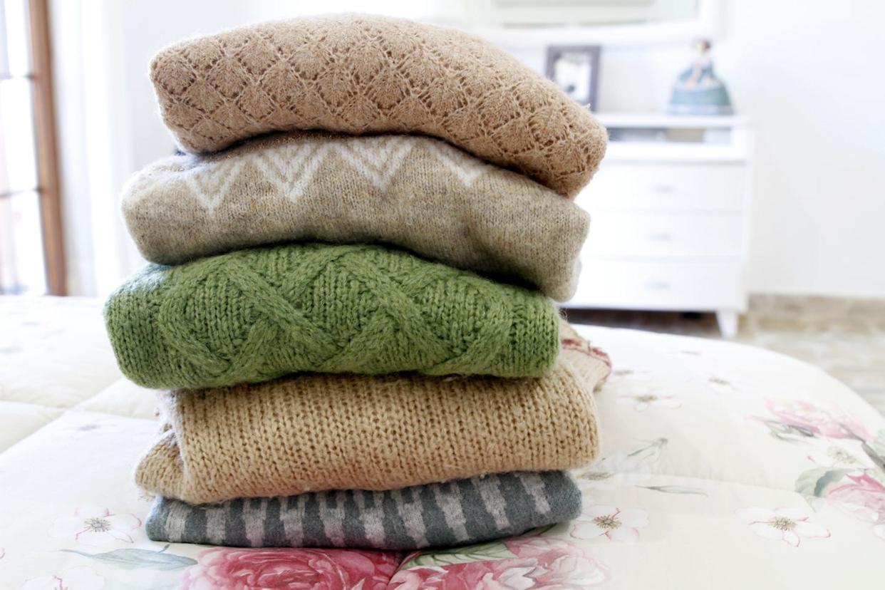 Pile de pulls chauds sur un lit