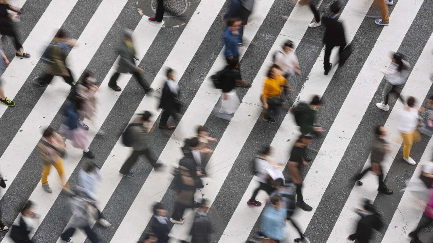 Vue d'ensemble floue : des personnes traversent un passage piéton.