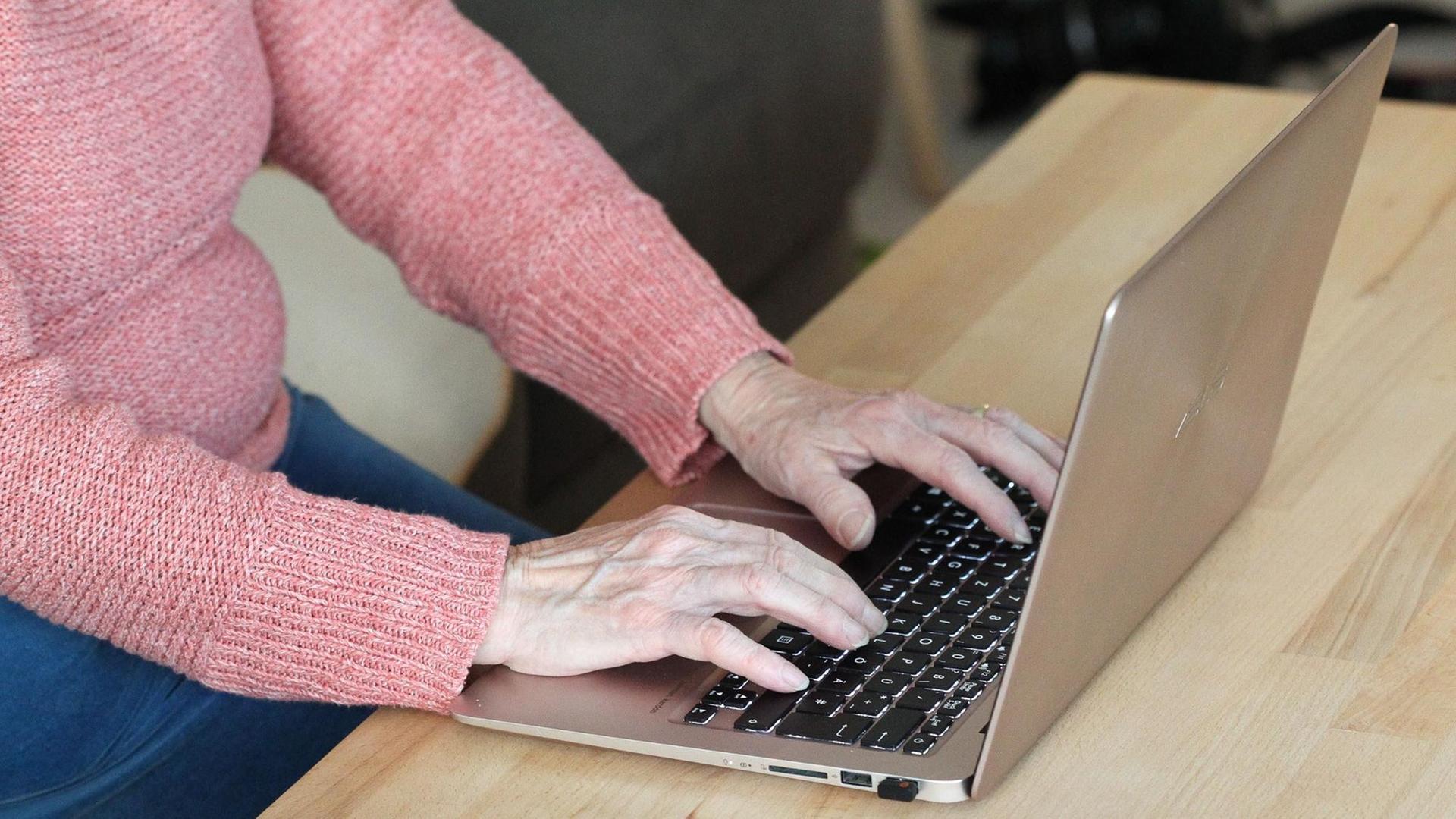 Les mains d'une senior sur le clavier d'un ordinateur portable. Les mains d'une senior sur le clavier d'un ordinateur portable.