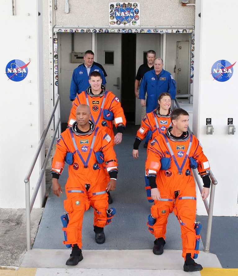 Les quatre astronautes de la mission Artemis II quittent un bâtiment après une répétition générale.