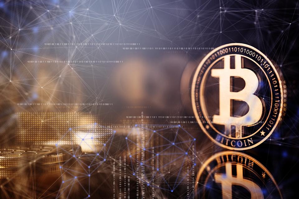 Bitcoin en or entouré de graphiques.