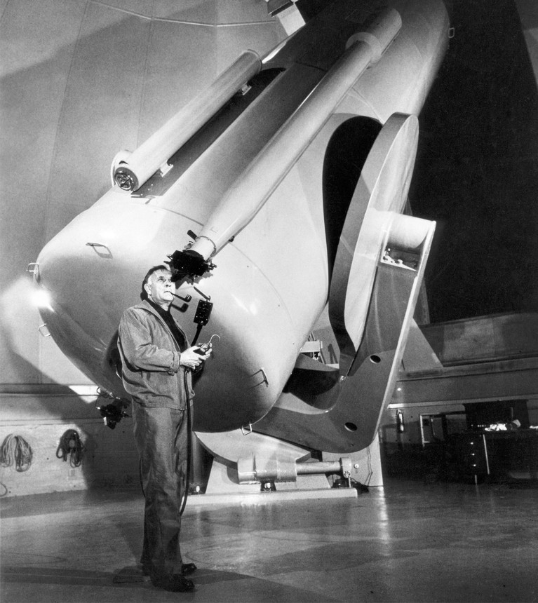 Edwin Hubble utilisant un grand télescope dans un observatoire.