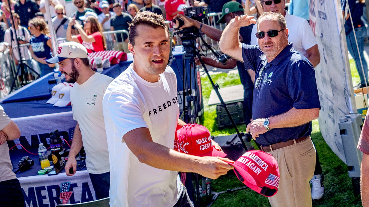 Charlie Kirk lançant un chapeau Make America Great Again à la foule à l'Université Utah Valley