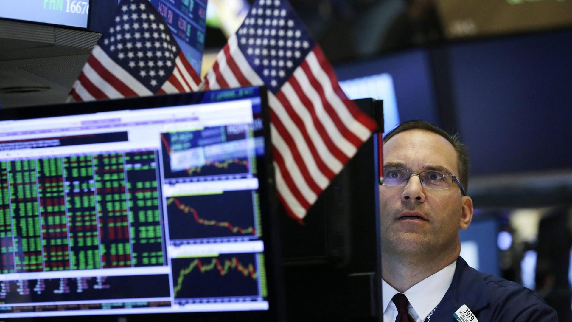 Un trader derrière des écrans avec des drapeaux américains. Un trader derrière des écrans avec des drapeaux américains.