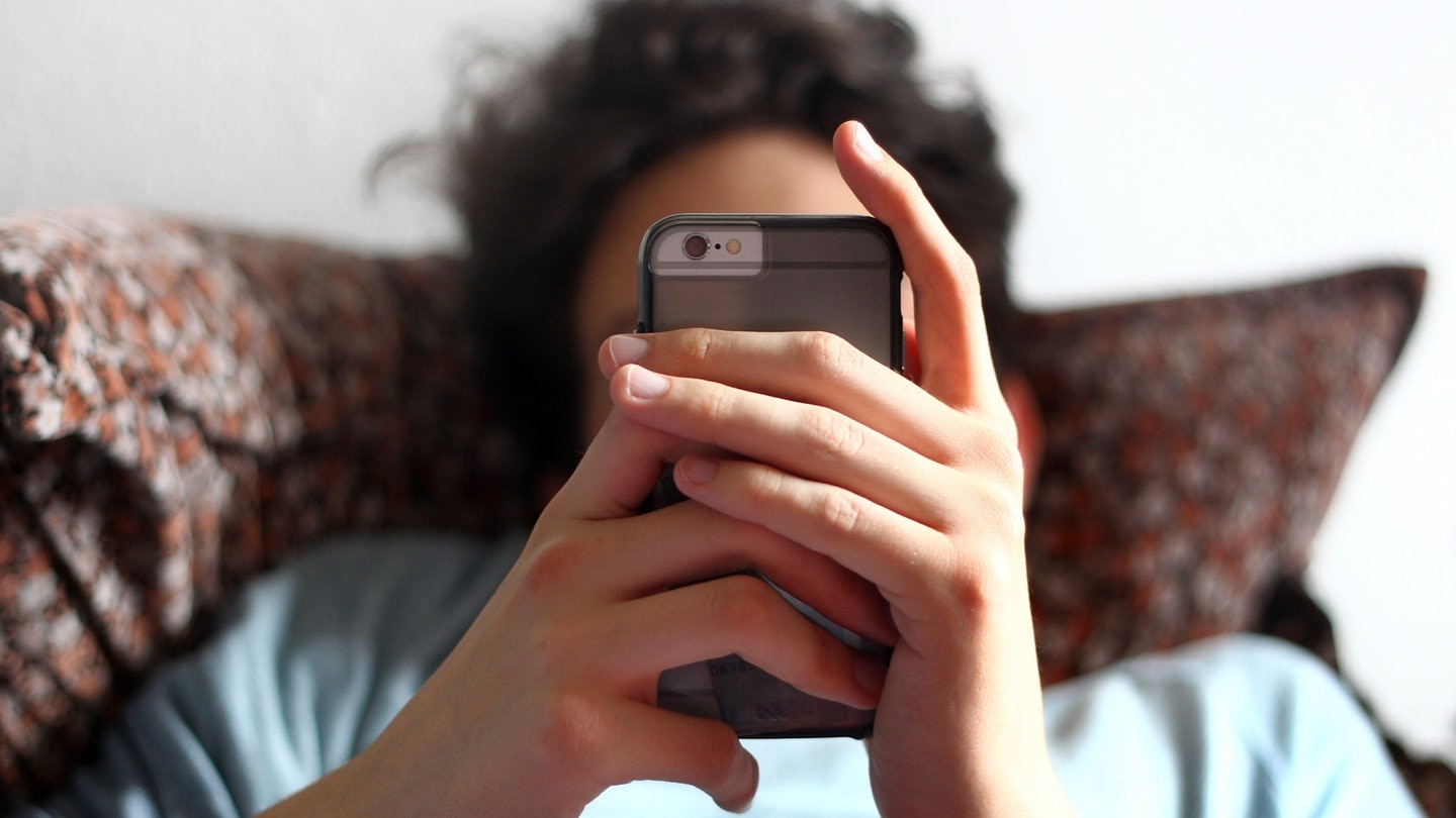 Un adolescent consulte son téléphone