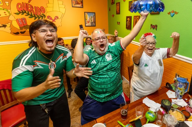 Des fans du Mondial, Eduardo Garcia-Gutierrez, à gauche, Cesar Corona et Carmen Gutierrez célèbrent le premier but du Mexique lors de leur victoire 2-0 sur l’Équateur mardi soir, 30 juin 2026, au restaurant Los Tres Chiles à Santa Rosa. (John Burgess/The Press Democrat)