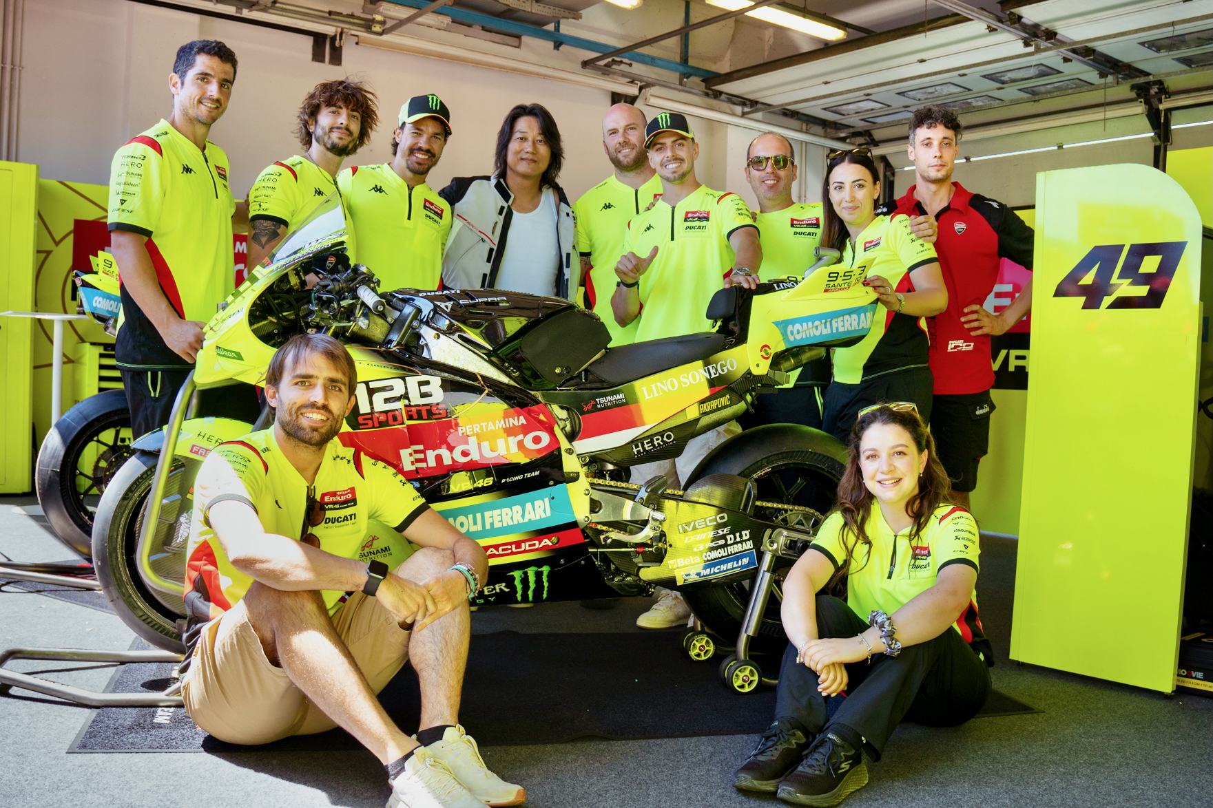 Sung Kang avec l'équipe de Pertamina Enduro VR46 Racing Team aux côtés d'une moto de course MotoGP avec la marque 12B SPORTS