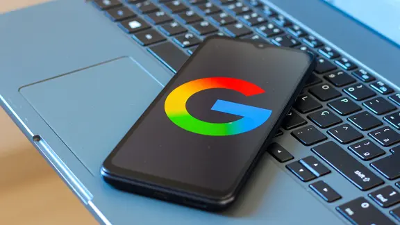 Un téléphone sur un clavier d'ordinateur, affichant le logo Google