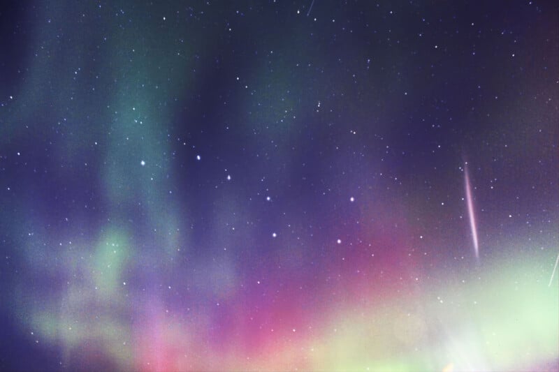 Une vibrante aurore boréale affiche une lumière verte et magenta à travers un ciel nocturne étoilé.