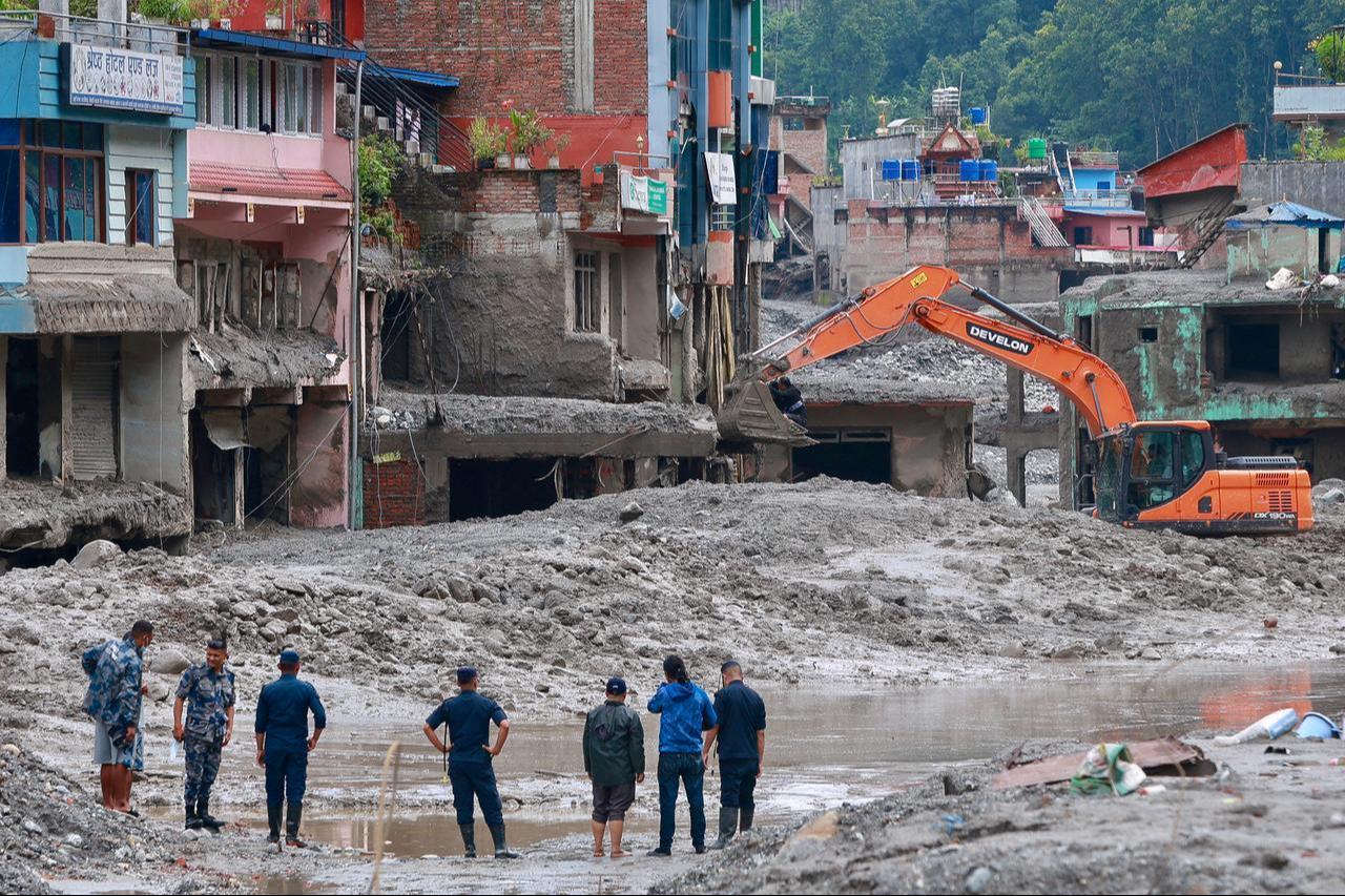 Des ouvriers utilisent des excavatrices pour déblayer la boue au Dhunge Bazaar à Nuwakot, Népal, le 29 août 2026. (Photo AFP)