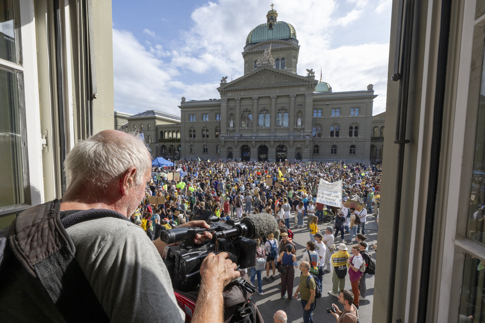 Kameramann filmt nationale Klimademo auf dem Bundesplatz in Bern
