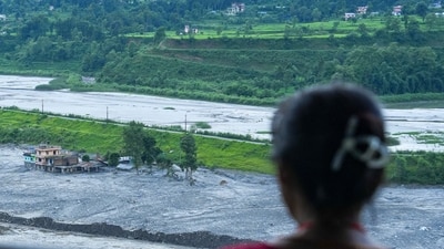 Nuwakot: Des personnes observent une structure endommagée près de la rivière Trishuli après les inondations.