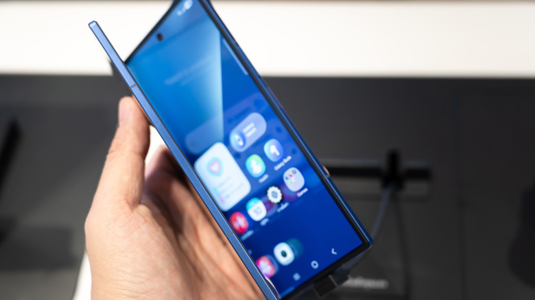 Un Samsung ZFold partiellement ouvert, tenu dans une main.