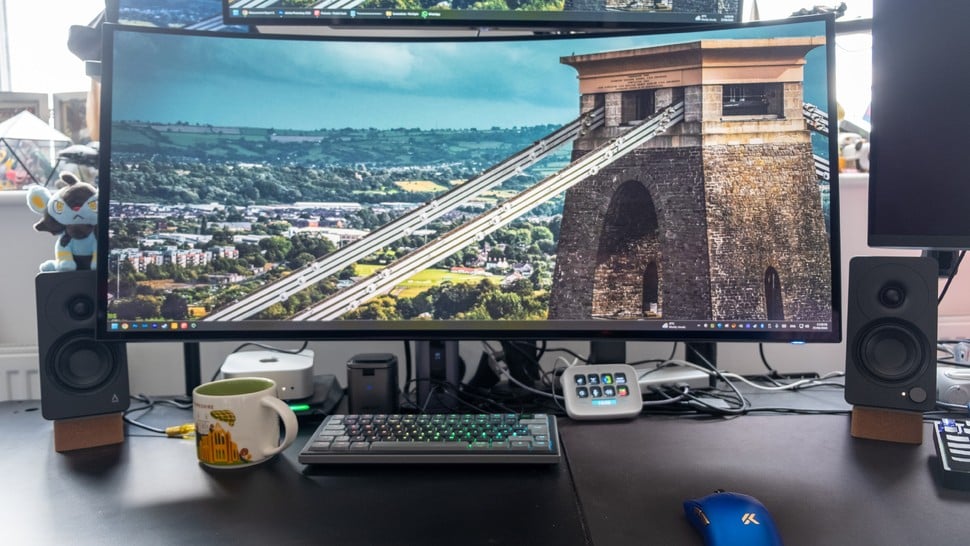 Enceintes Creative XF1 à côté d'un moniteur de jeu ultrawide