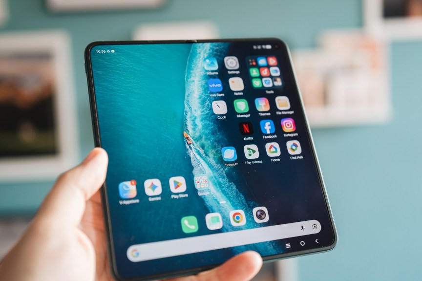 Une main tenant un Vivo X Fold 6 déplié, mettant en avant son écran.