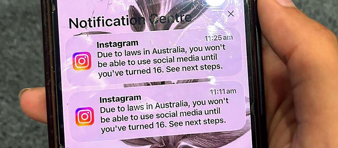 Un adolescent tenant un téléphone avec un message de la plateforme de médias sociaux Instagram