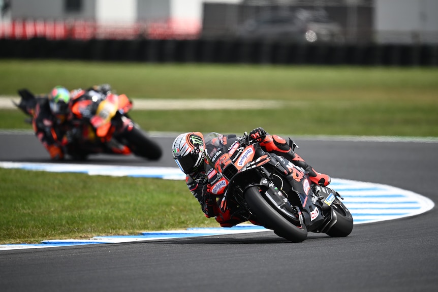 Un pilote de MotoGP prenant un virage sur sa moto.