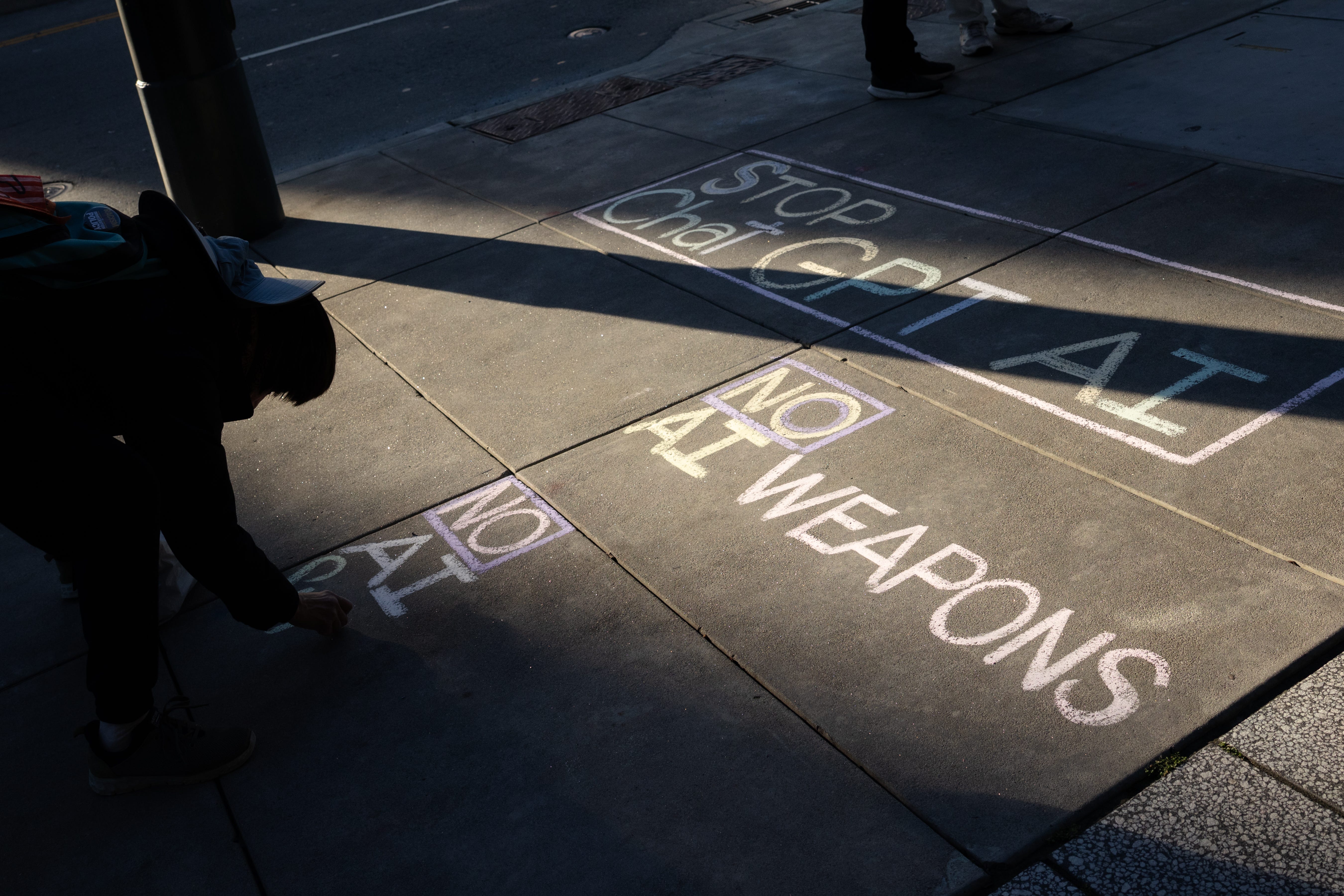 Un manifestant écrit un message contre l'intelligence artificielle devant le siège d'OpenAI à San Francisco.