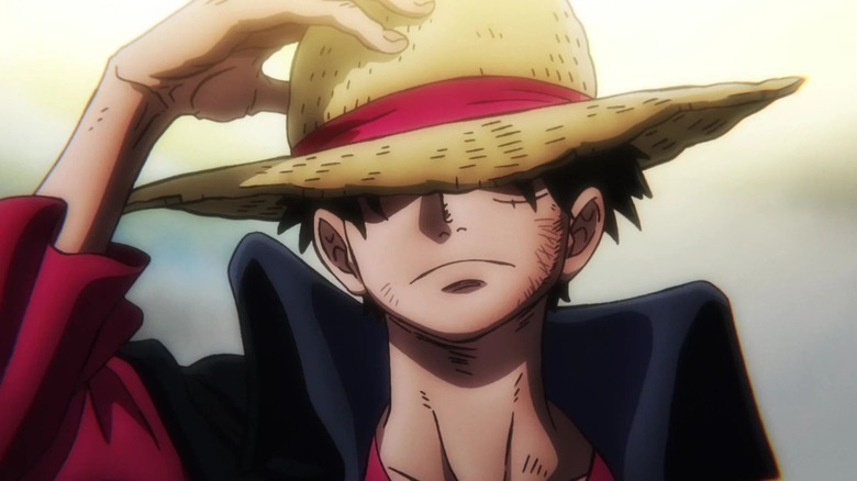 Luffy tenant son chapeau de paille avec un regard déterminé dans One Piece