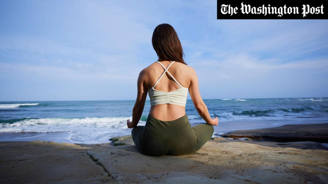 Une femme méditant sur la plage