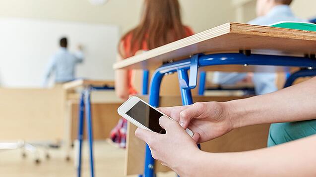 Un élève utilisant un téléphone en cours.